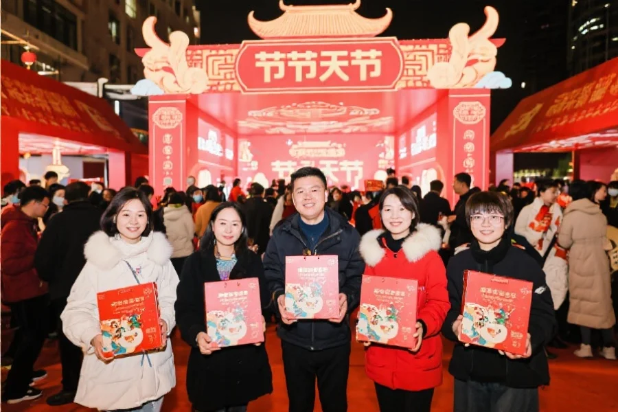 参与者在节庆活动现场领取精美礼品并合影留念